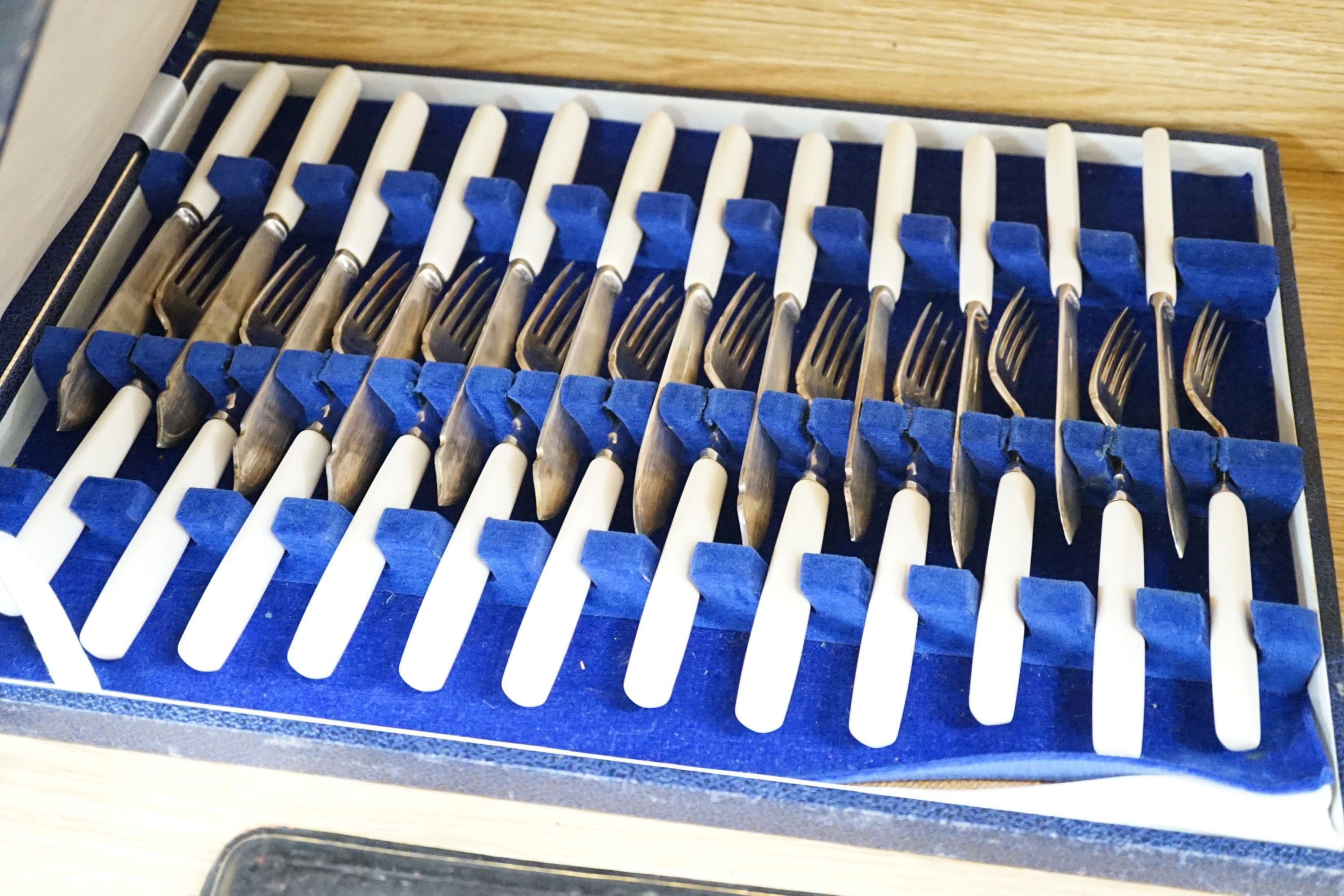 A cased modern silver three piece condiment set, a cased set of twelve Edwardian silver teaspoons, London, 1903 (lacking tongs) and two plated fish services.